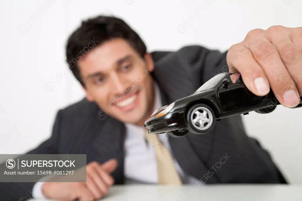 Mid-adult businessman playing with toy car