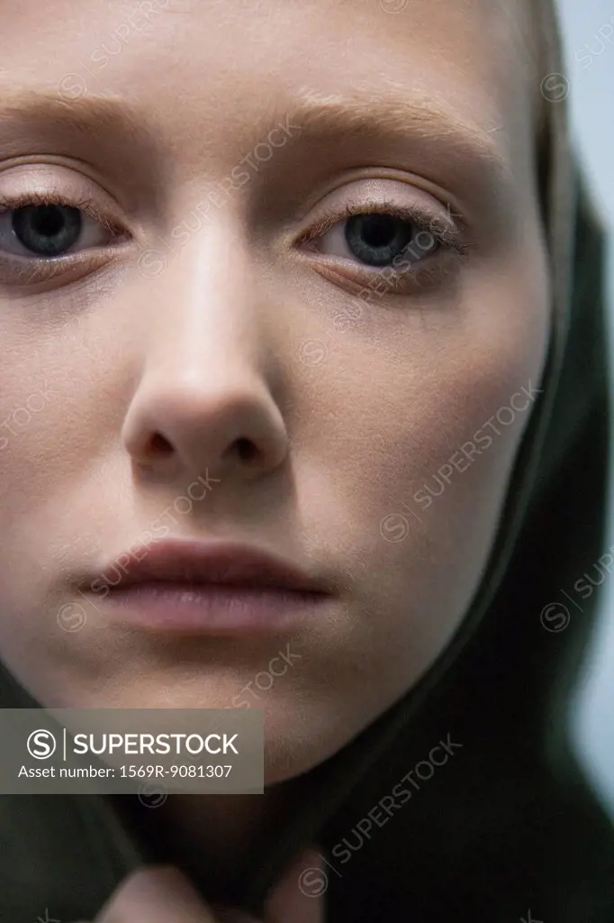 Young woman wearing hood, close-up portrait