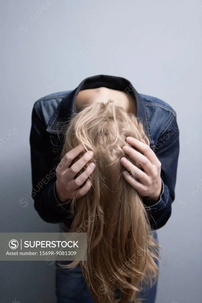 Young woman bending over, tossing hair