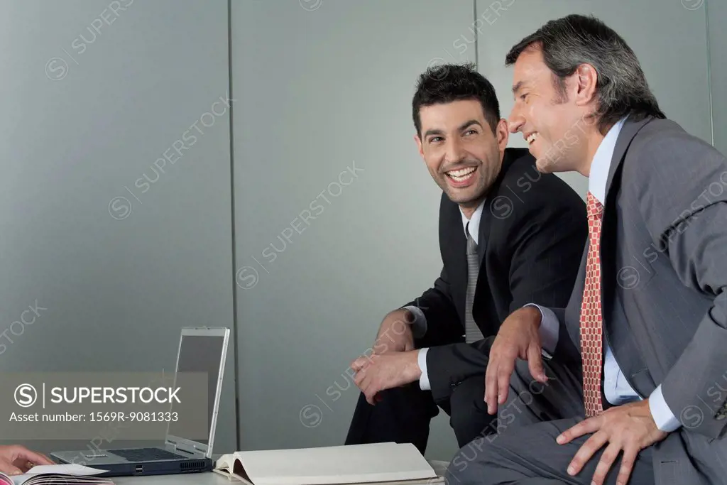 Businessmen in meeting, smiling