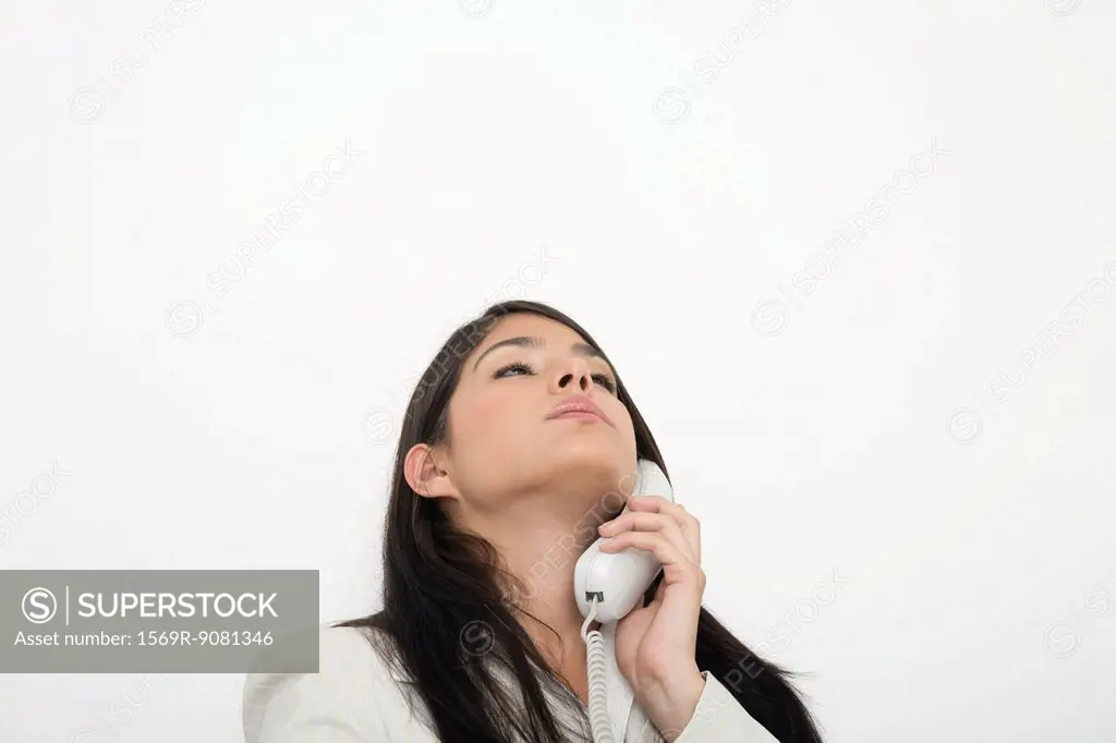 Young businesswoman talking on landline phone
