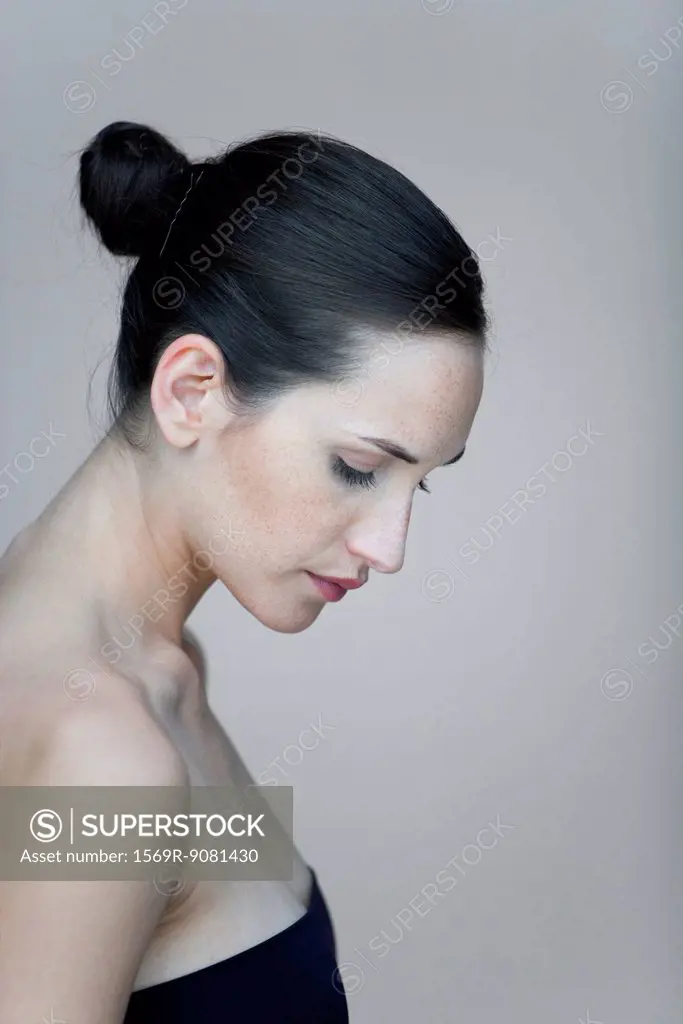 Young woman in profile, looking down, portrait
