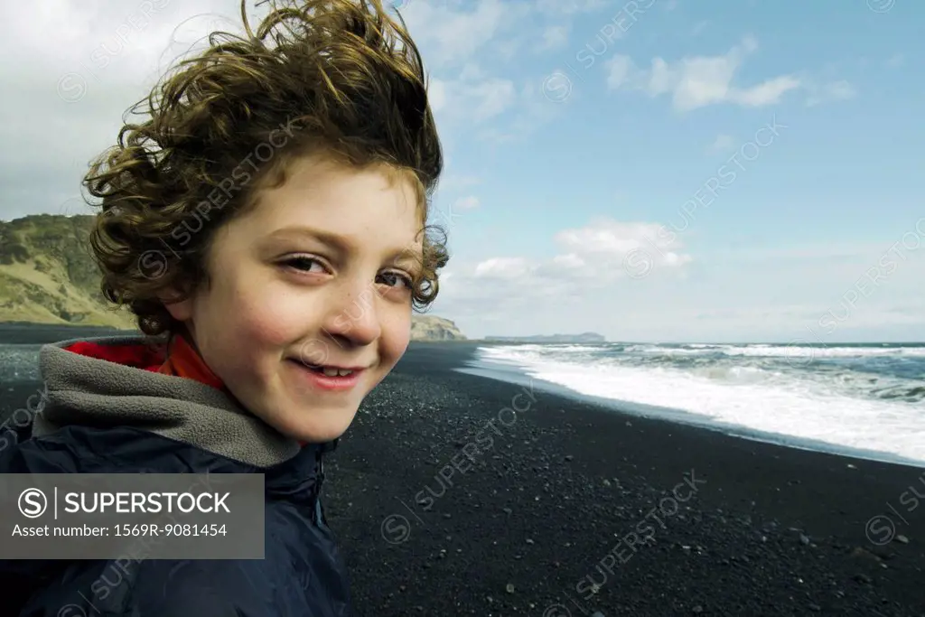 Portrait of a boy smiling on a beach, iceland