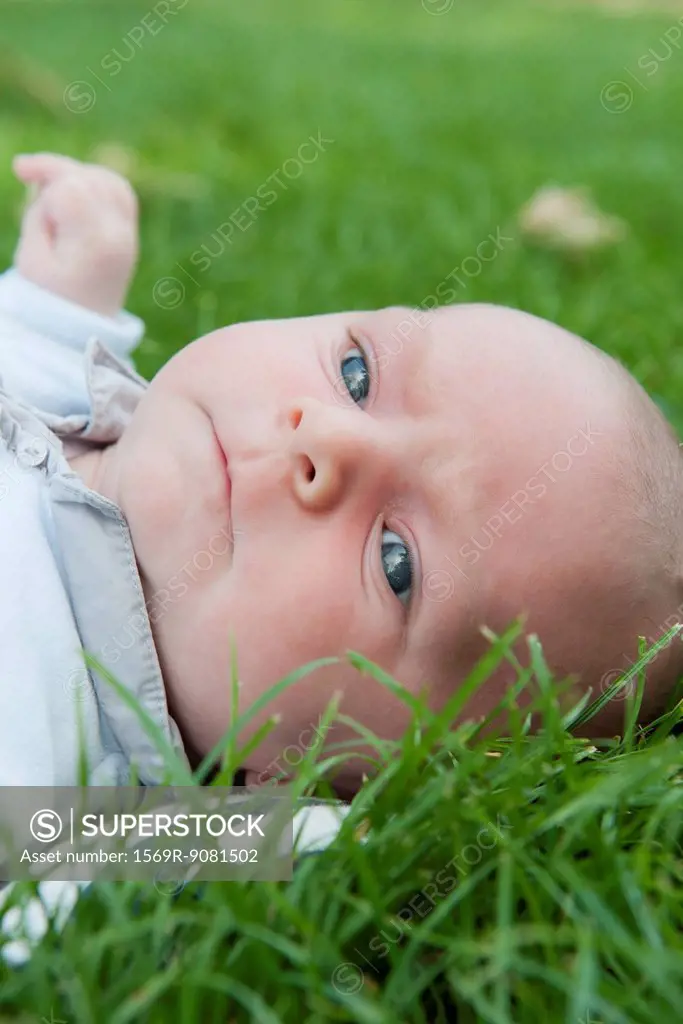 Baby boy lying in grass