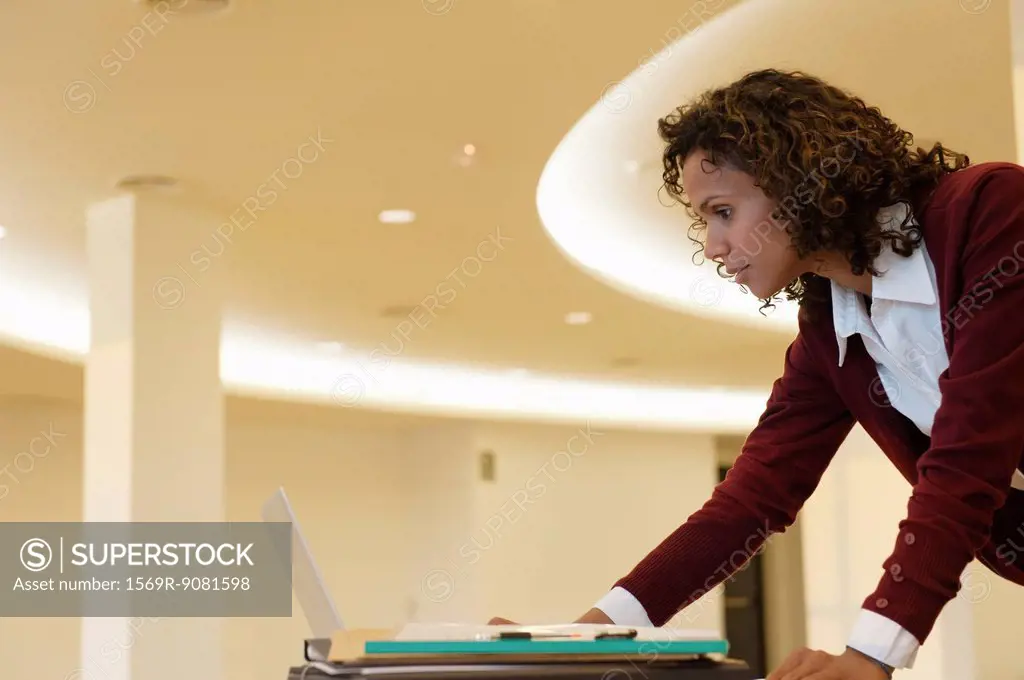 Mid-adult businesswoman working on laptop computer