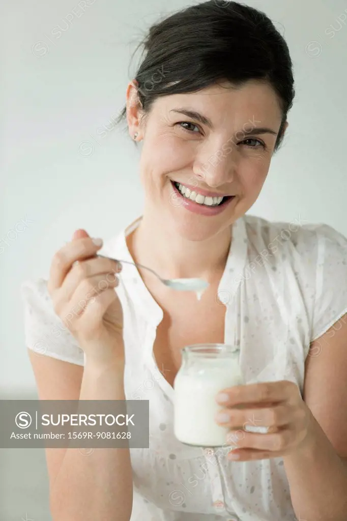 Woman eating yogurt, portrait