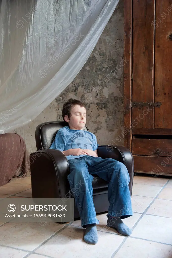 Boy napping in armchair