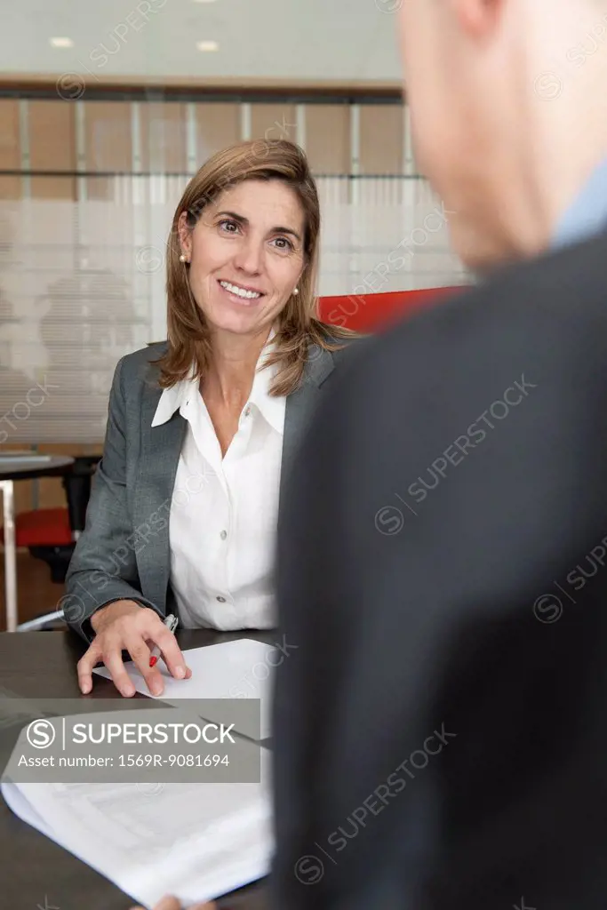 Businesswoman assisting client in office