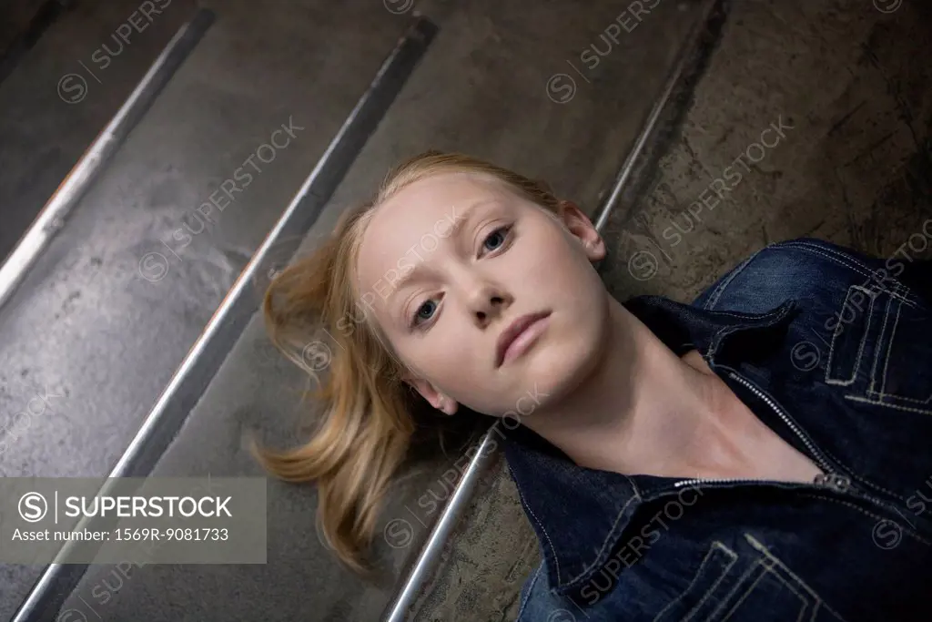 Young woman lying on stairs, portrait