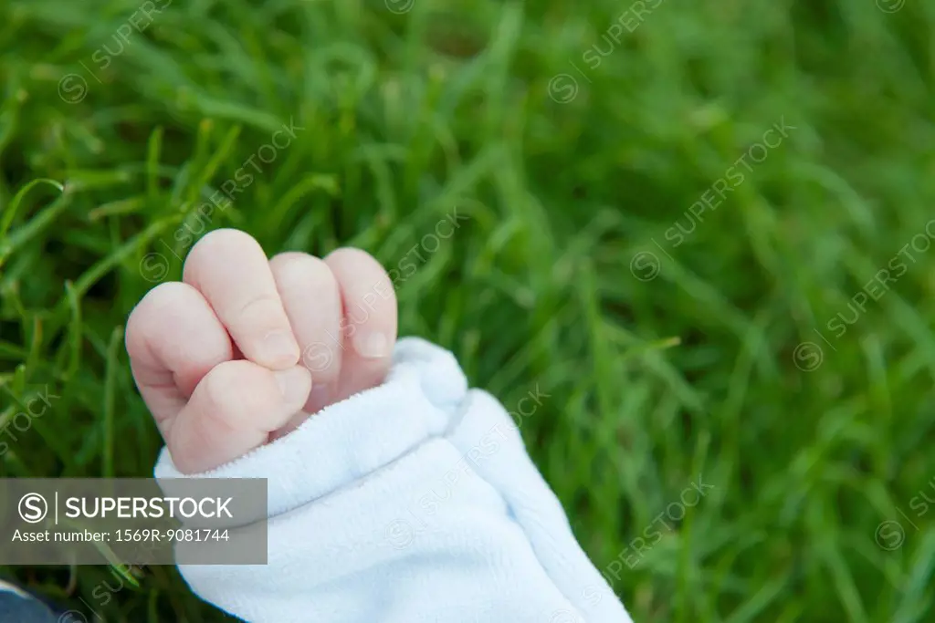 Baby's hand, grass in background