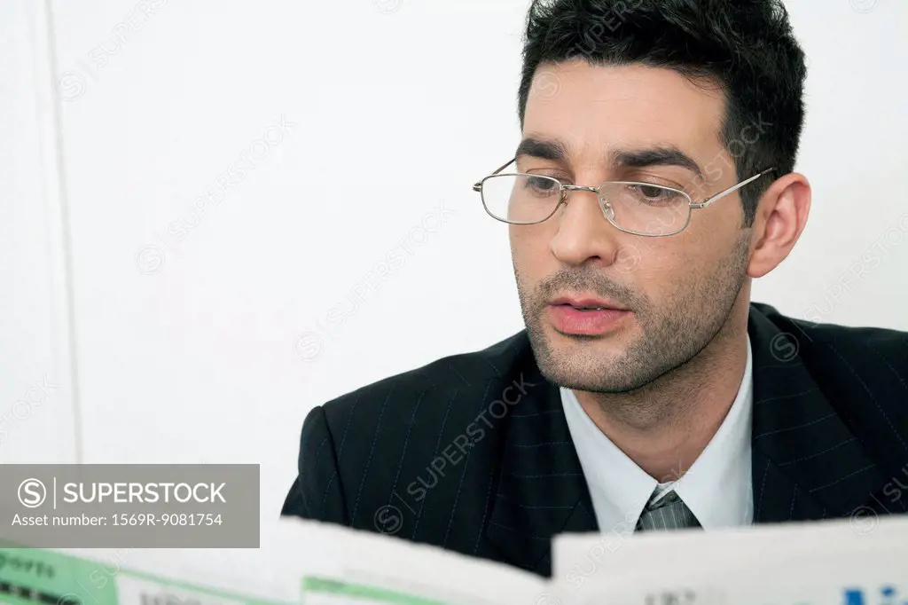 Mid-adult businessman reading newspaper