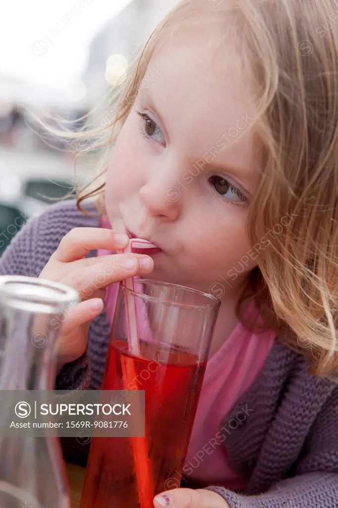 Little girl drinking beverage with straw