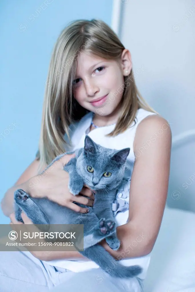 Girl holding Russian Blue, portrait