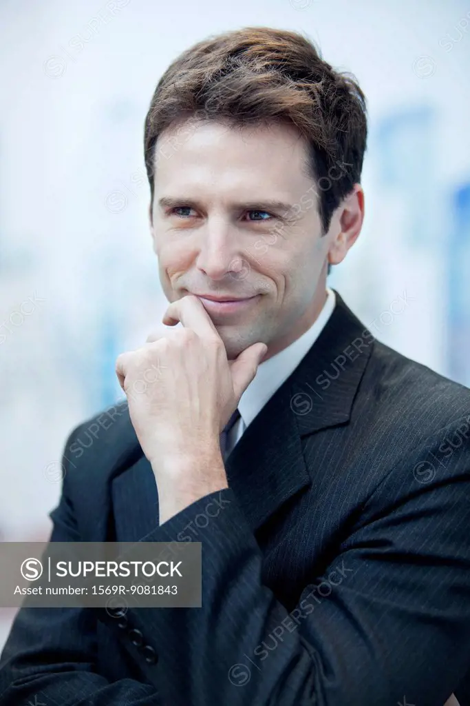 Businessman smiling and looking away in thought, portrait