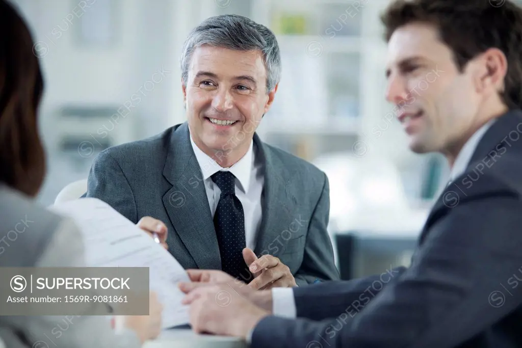 Businessman discussing document with colleagues