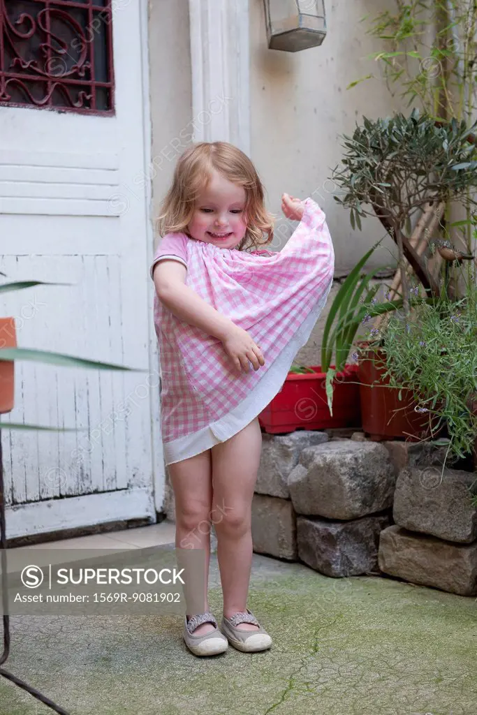 Little girl playing with dress, portrait