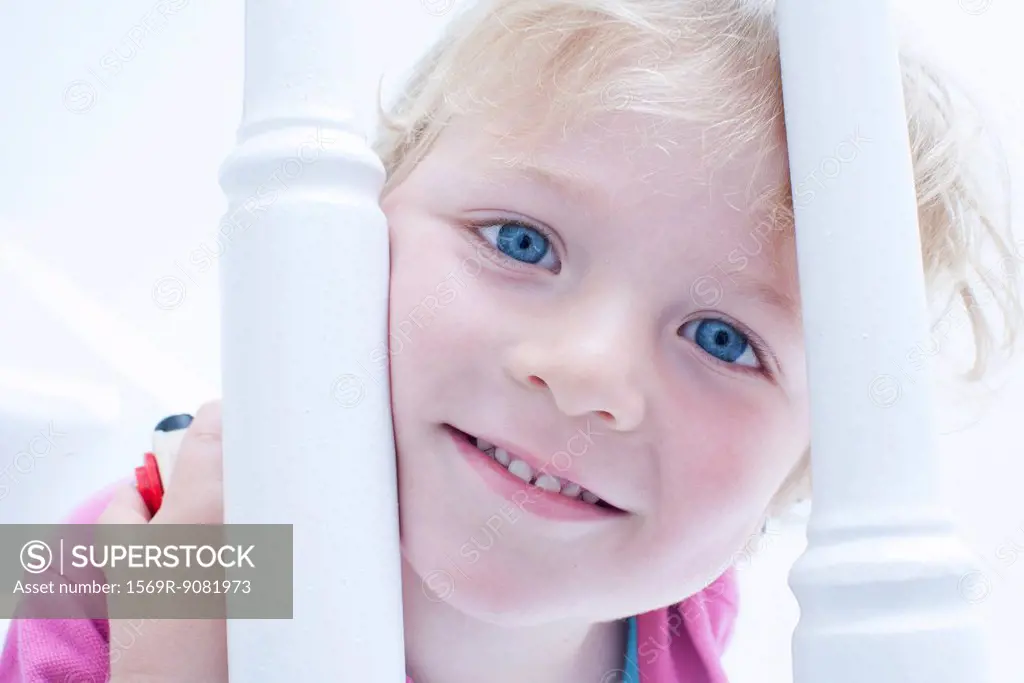 Little boy looking through banister, portrait