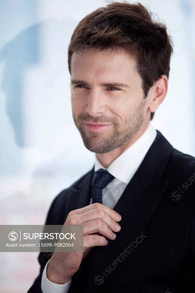 Businessman looking away, smiling, portrait