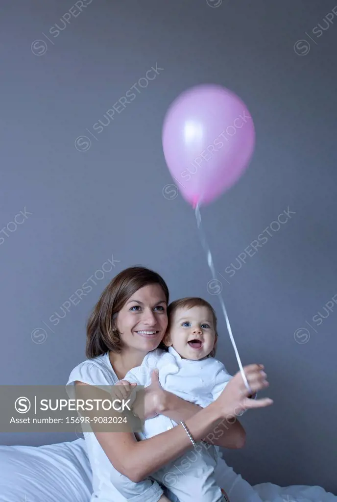 Mother and baby playing with balloon