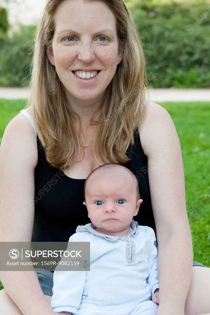 Mother sitting outdoors with baby boy, portrait