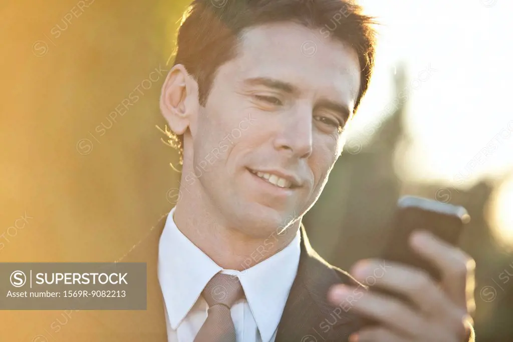 Businessman checking cell phone, portrait