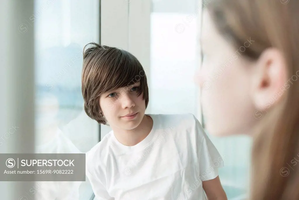 Teenage boy leaning against window