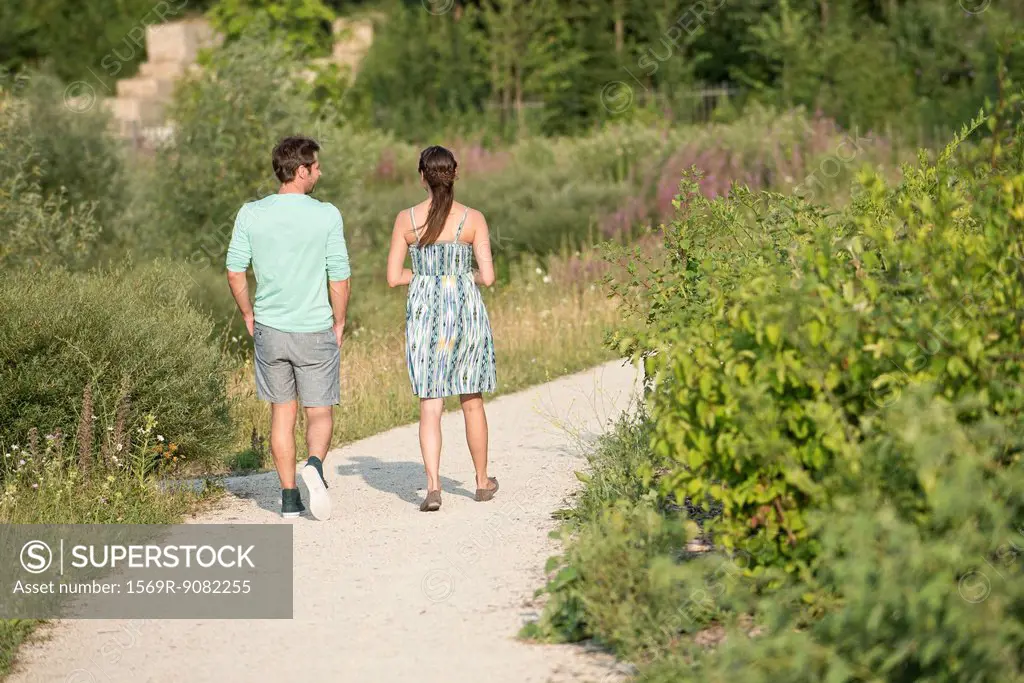 Couple together on walk through park, rear view