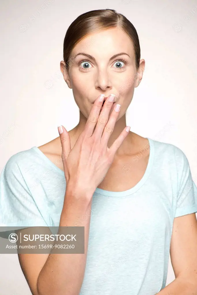 Woman covering mouth in surprise, portrait