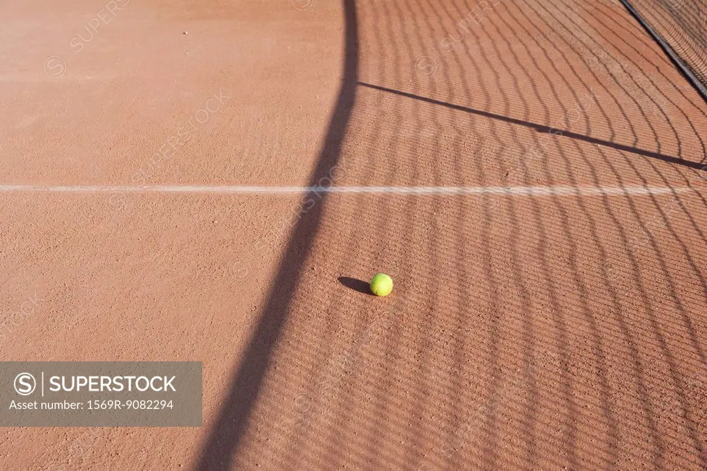 Shadow of net in tennis court over tennis ball