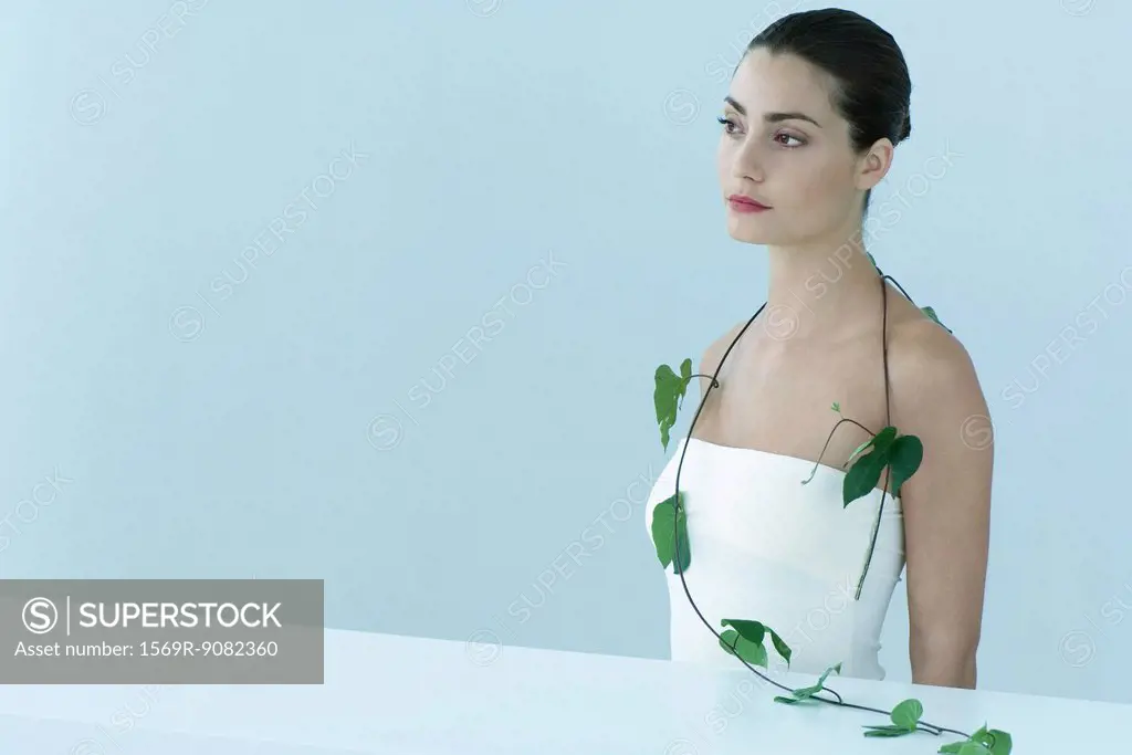 Young woman with leafy vine hanging around shoulders