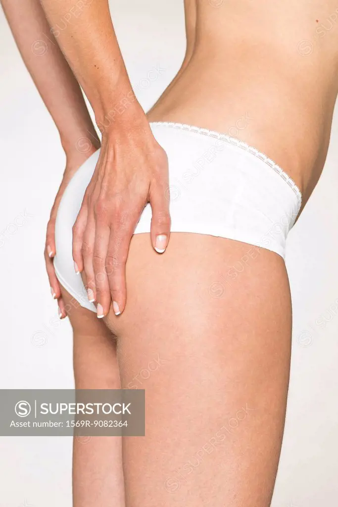 Woman in underwear lifting buttocks with hands, cropped