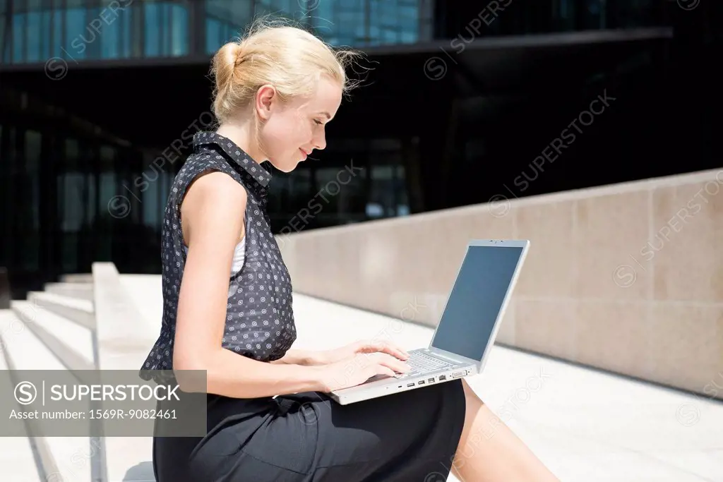Businesswoman using laptop working outdoors