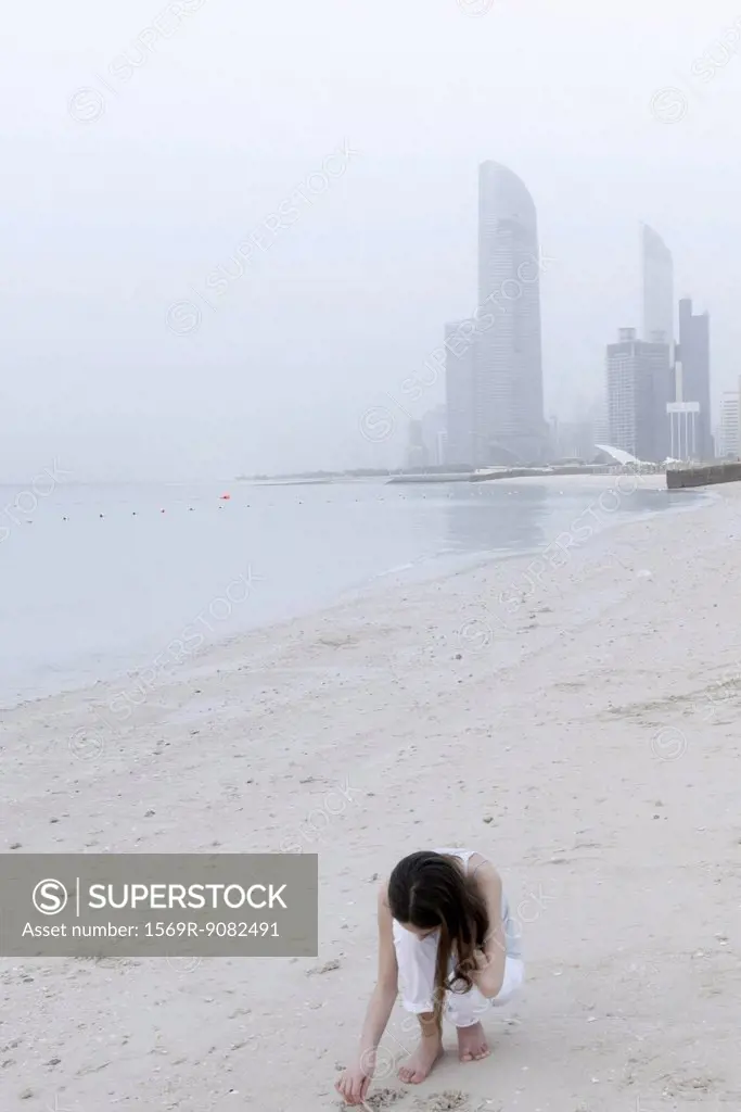 Girl looking for seashells at the beach