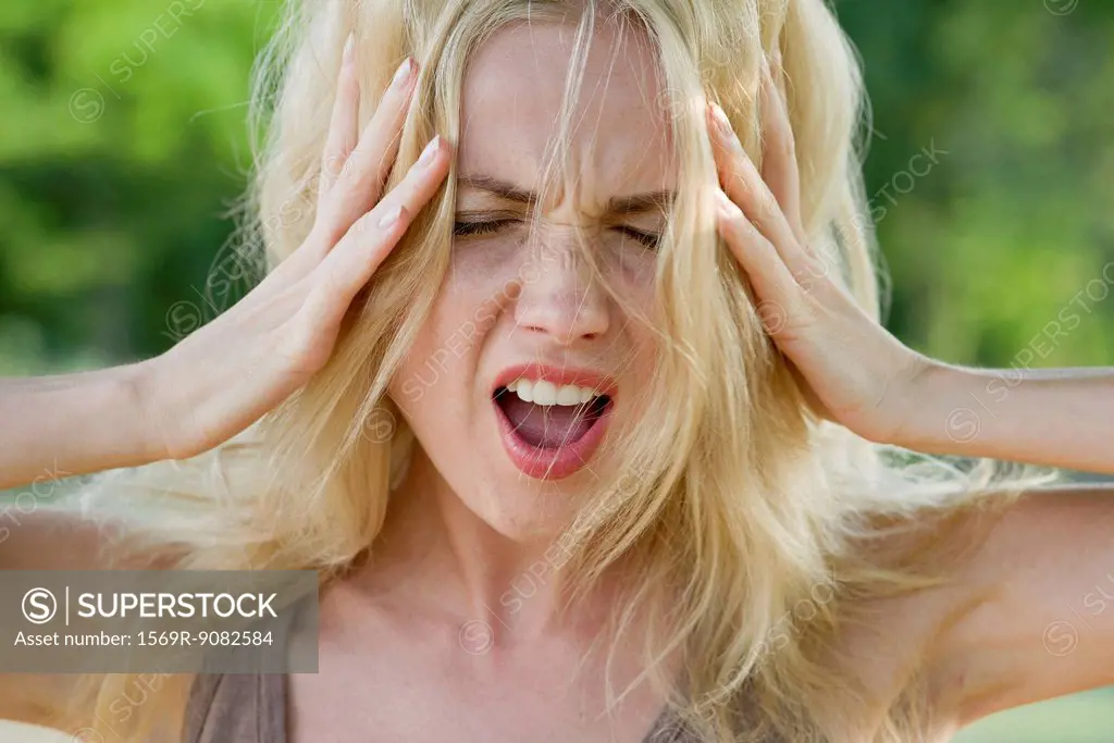 Woman with head in hands, screaming