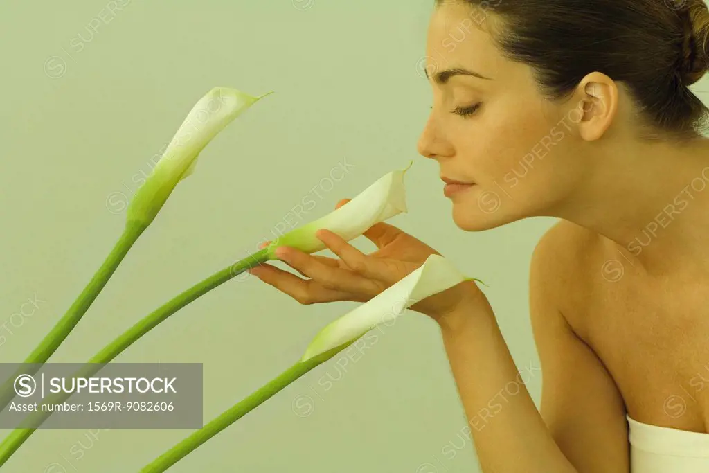 Young woman smelling calla lilies