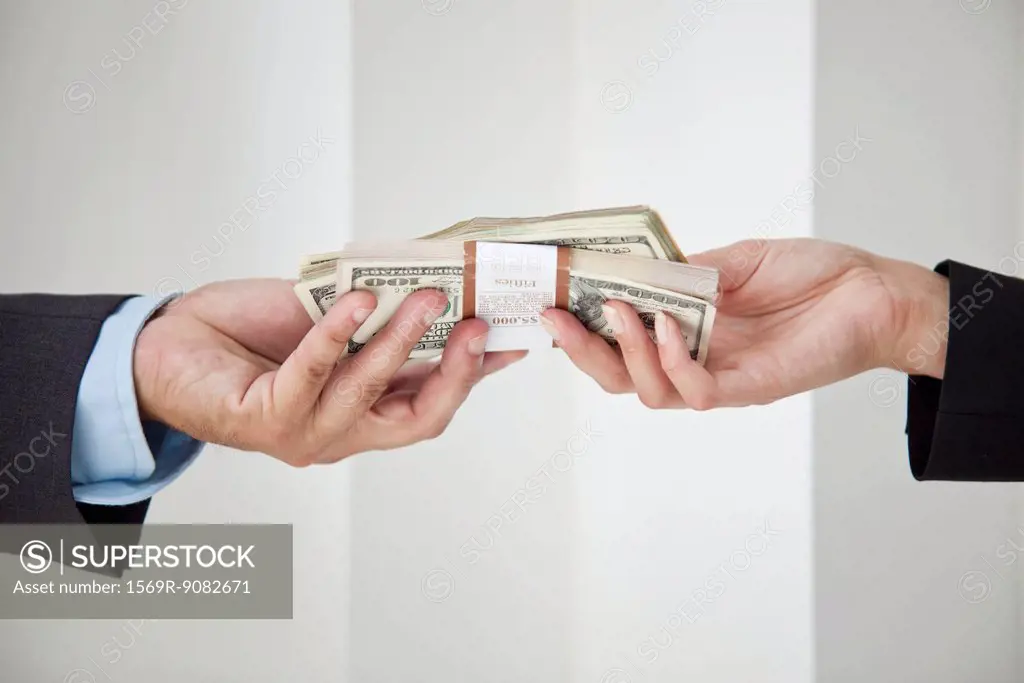 Businessman and businesswoman holding stacks of cash