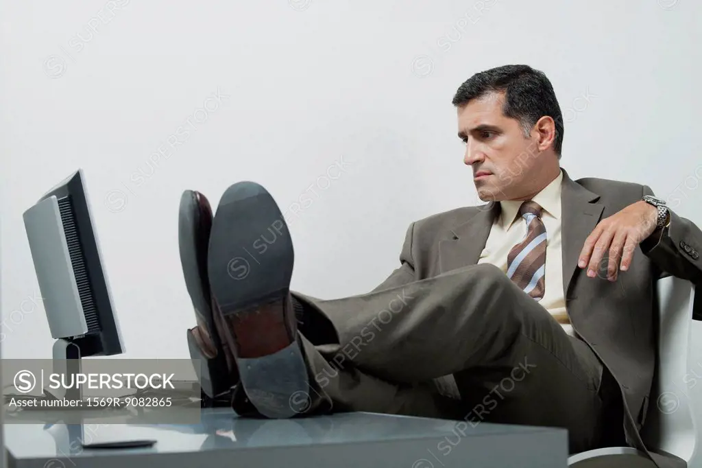 Businessman sitting in office with feet up on desk