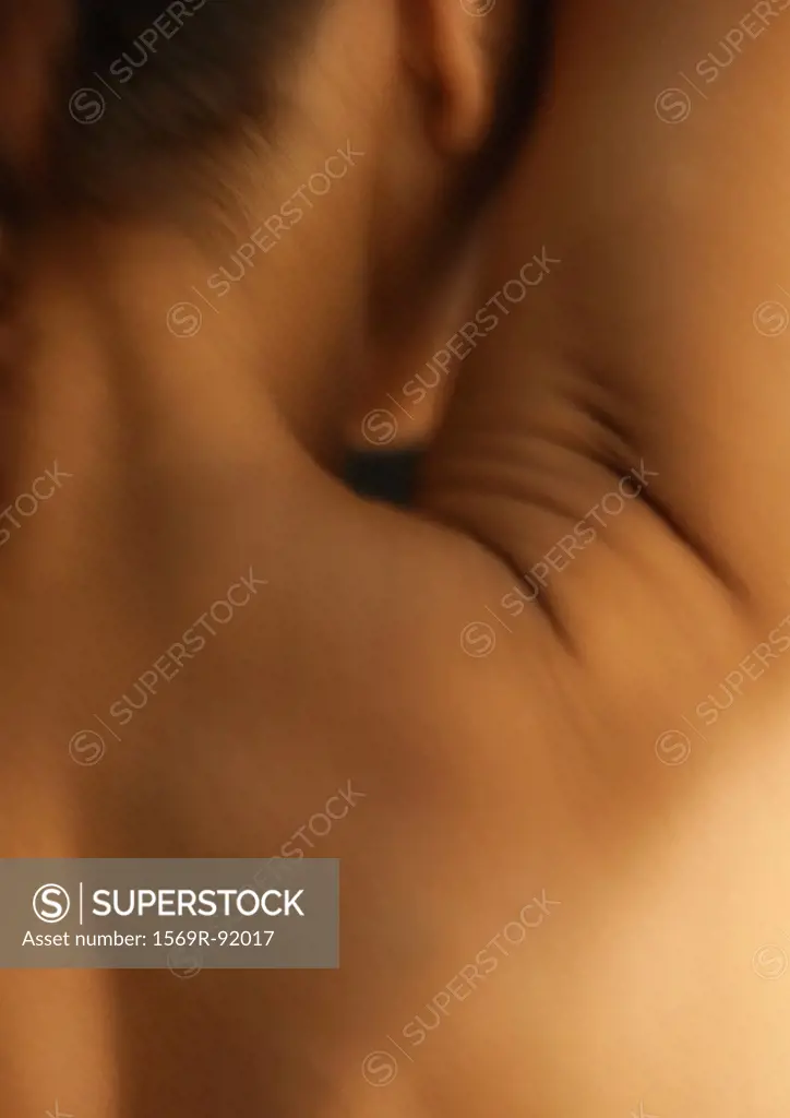 Woman´s neck and bare shoulder with arm up, rear view, close-up