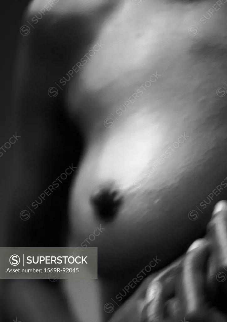 Woman´s bare breast and fingers, blurred close-up, B&W