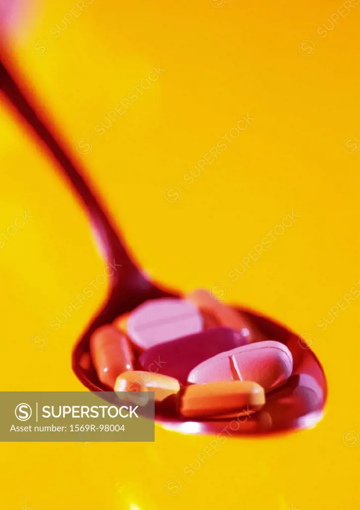 Various pills in spoon, close-up