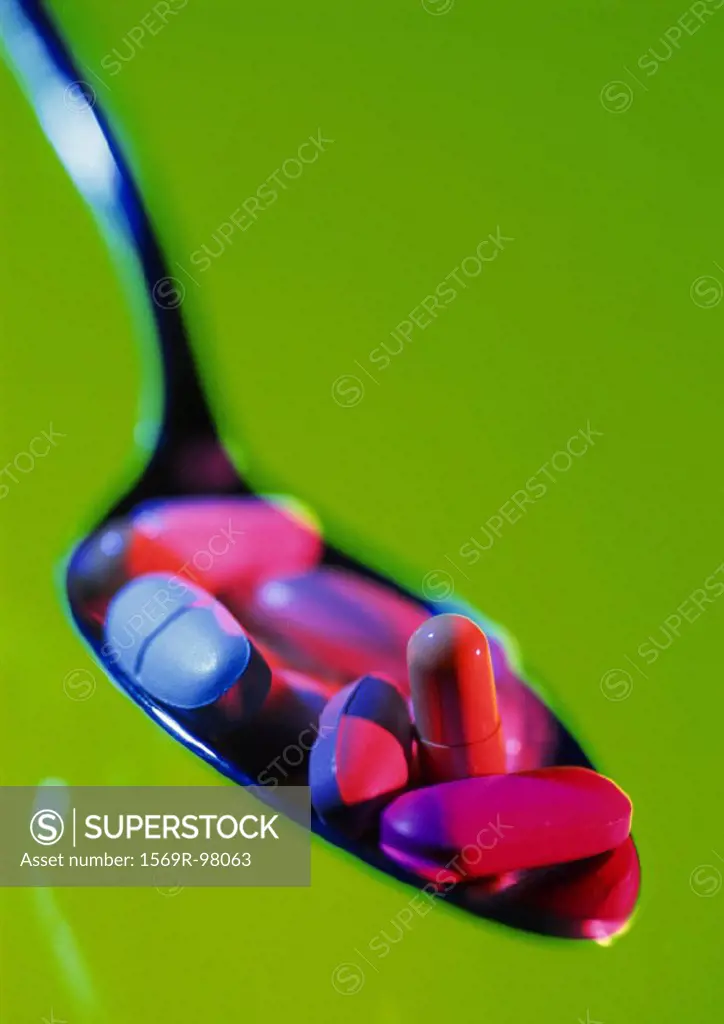 Various pills in spoon, close-up