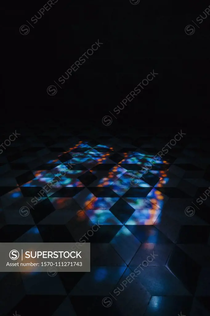 Kaleidoscope reflection of lights on tile floor