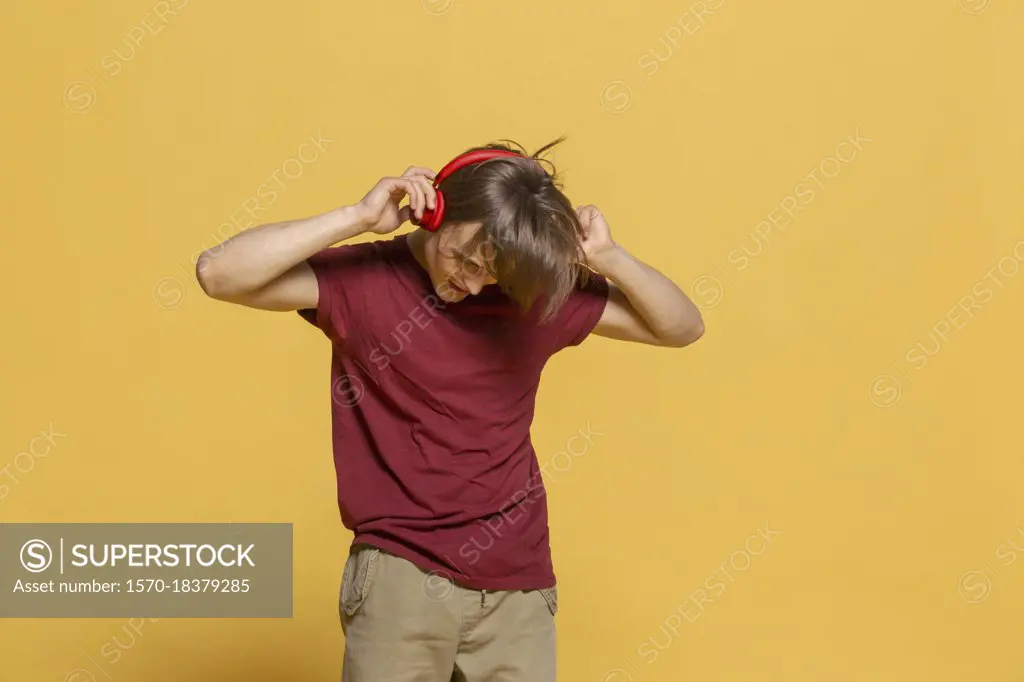 Carefree young man with headphones listening to music