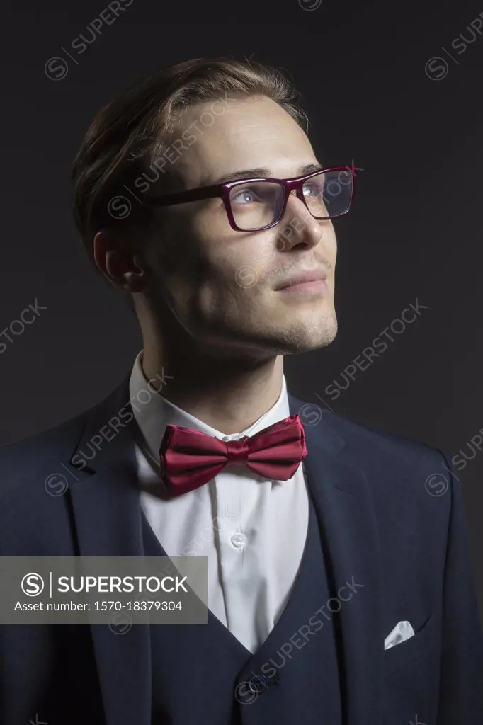 Portrait thoughtful, handsome young man in suit and eyeglasses
