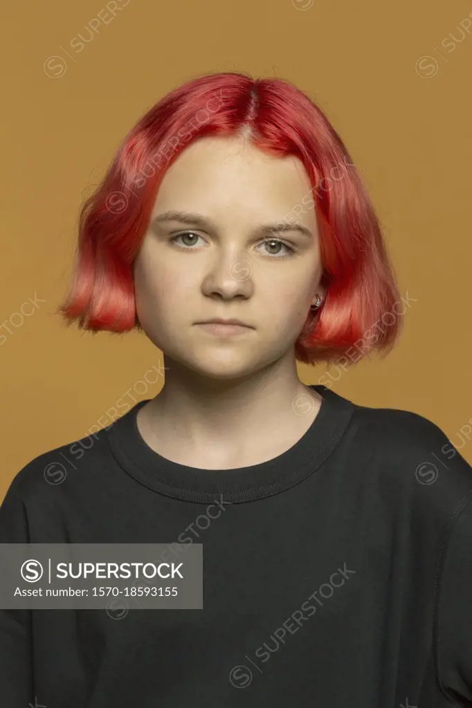 Portrait serious teenage girl with dyed red hair