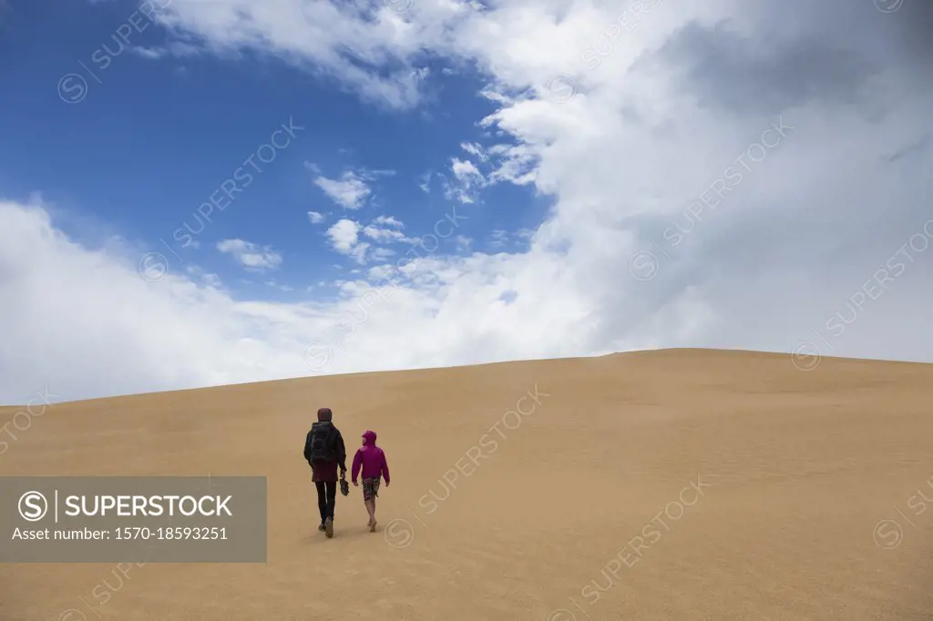 Mother and son walking along remote sand dunes, Wilsons Promontory, Victoria, Australia