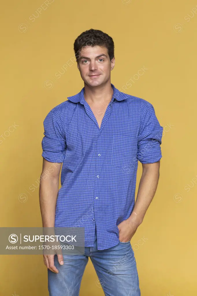 Portrait confident man in blue on yellow background