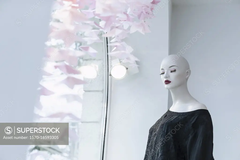 Mannequin with eyes closed in boutique window