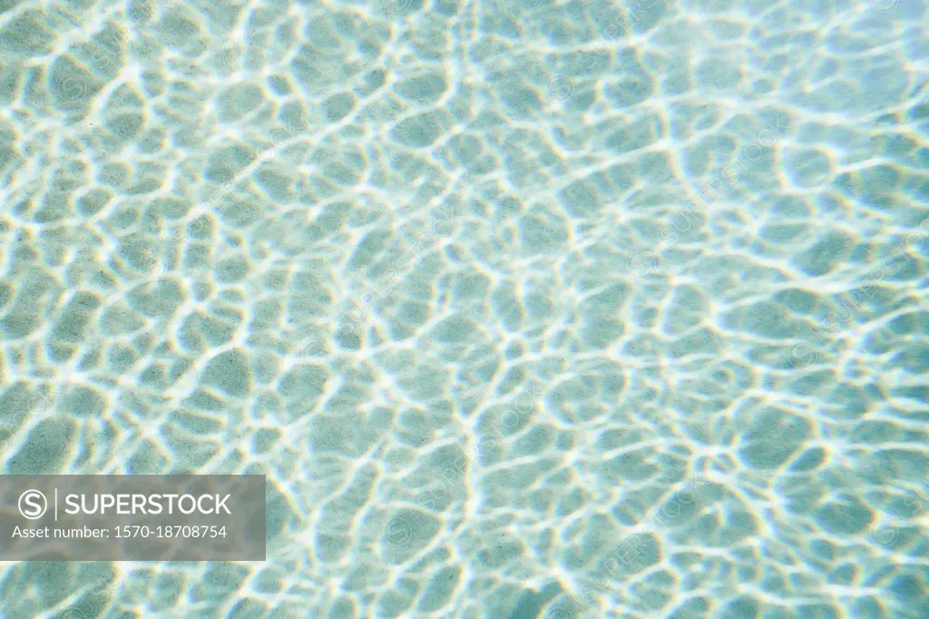 Reflection forming pattern over blue swimming pool water