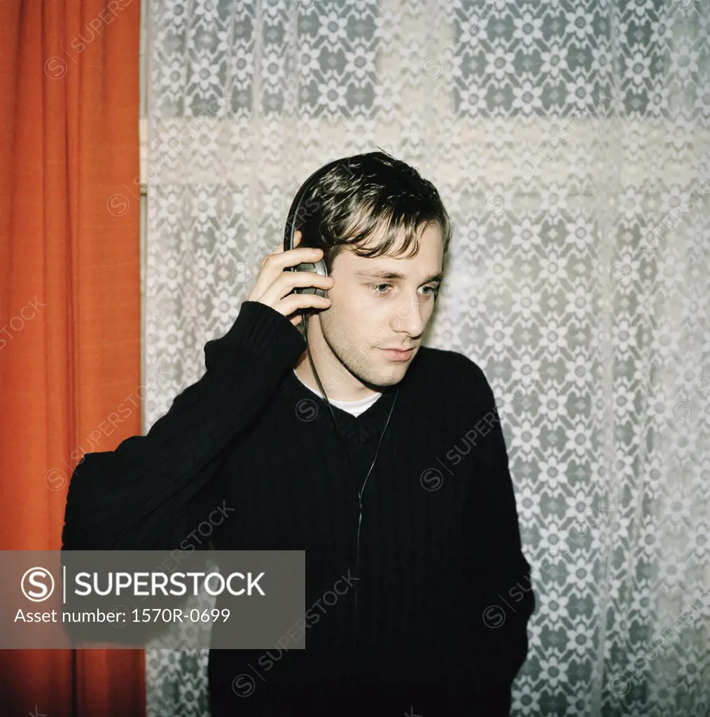 A young man listening to music on headphones
